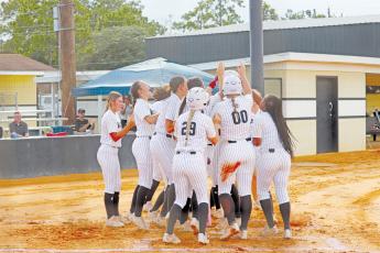 ERIC DENTY / Staff The Lady Jackets celebrate with Addison Thompson after her two-run homer in the first inning against Ware County High.
