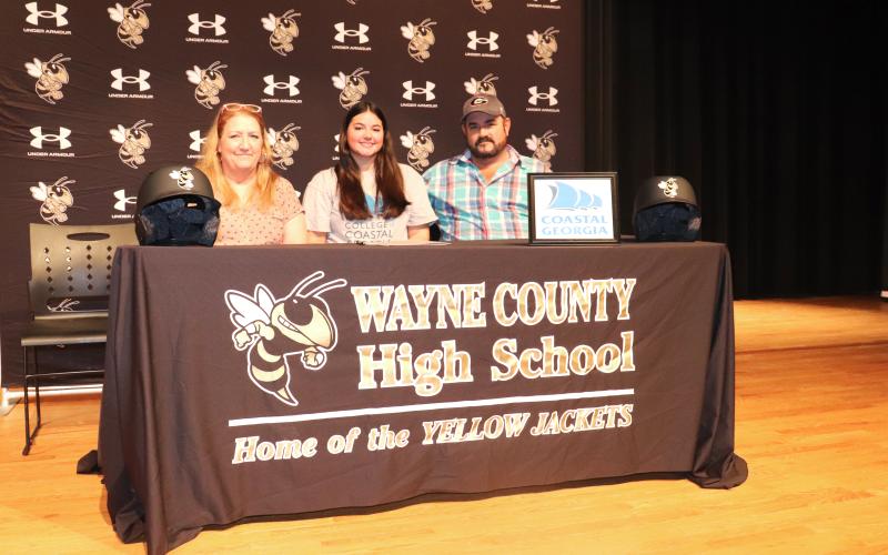 ERIC DENTY / Staff Lady Jacket softball player Raeghan Harvey signed last week to play softball at the College of Coastal Georgia in Brunswick. She is joined by her mother, Ashlyn Croy, and father, Jason Harvey.