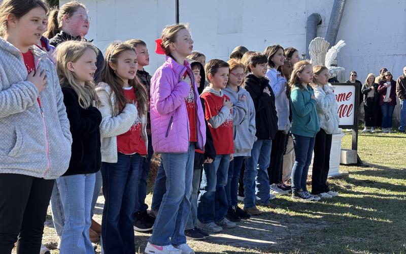 The students of the Screven Elementary Chorus sing the National Anthem during the ceremony dedicating the new Veterans Garden and proclaiming the Year of the Youth in Screven.