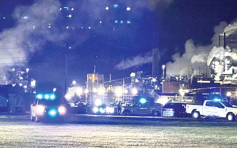 Flashing lights on law-enforcement vehicles compete with the lights from the RYAM plant following an incident of shots fired at the U.S. Hwy. 301 intersection with Jaycee Landing Road. No one was reported as injured in the incident, and investigation identified a suspect in the event.