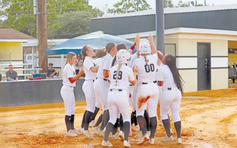 ERIC DENTY / Staff The Lady Jackets celebrate with Addison Thompson after her two-run homer in the first inning against Ware County High.