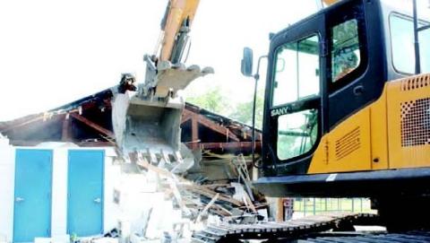 Excavators began demolition of the former Odum Elementary kindergarten building Thursday. This building was formerly part of a canning plant. 