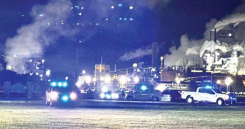 Flashing lights on law-enforcement vehicles compete with the lights from the RYAM plant following an incident of shots fired at the U.S. Hwy. 301 intersection with Jaycee Landing Road. No one was reported as injured in the incident, and investigation identified a suspect in the event.