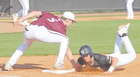 ERIC DENTY / Staff Jacket Haddy Peel dives safely back to first in a pick-off attempt in a game against Perry High.