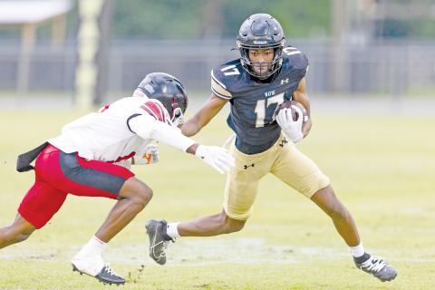 TREY GILLEY / Staff Jacket Trenten Houston looks for extra running room after hauling in a pass. 
