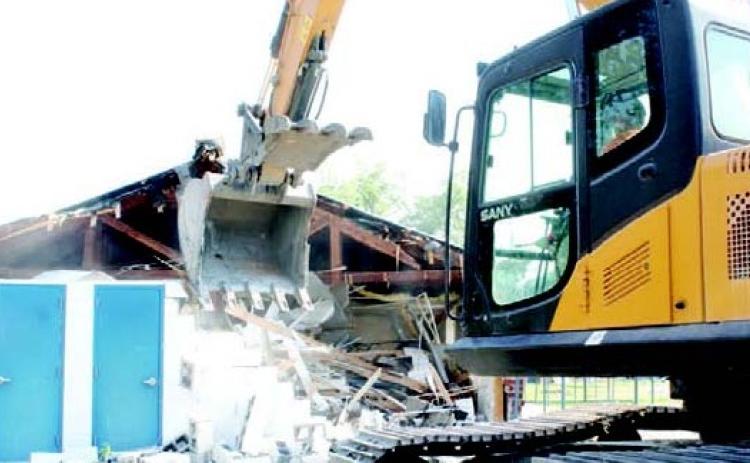 Excavators began demolition of the former Odum Elementary kindergarten building Thursday. This building was formerly part of a canning plant.