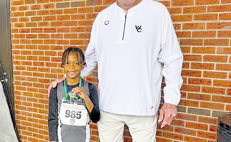 Terrence Ward is all smiles with Wayne County Recreation Department director Speck Echols after setting a state record in the U-8 boys long jump. 