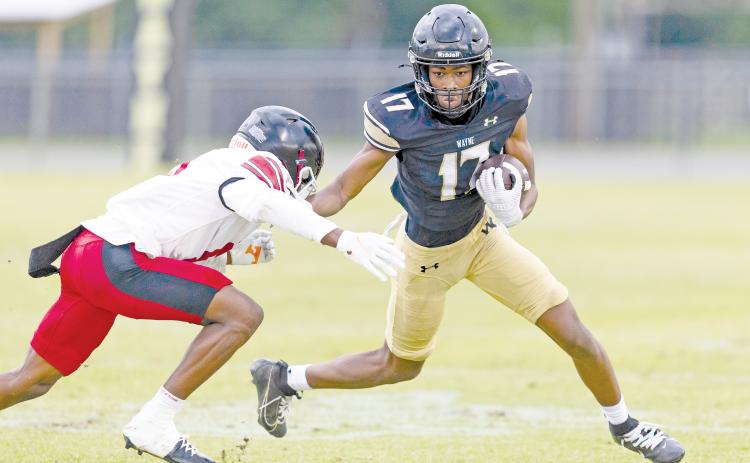 TREY GILLEY / Staff Jacket Trenten Houston looks for extra running room after hauling in a pass. 