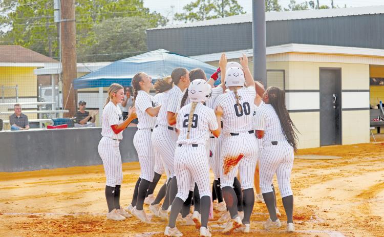 ERIC DENTY / Staff The Lady Jackets celebrate with Addison Thompson after her two-run homer in the first inning against Ware County High.