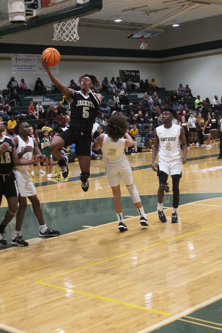 Jacket Dresus Johnson, No. 5, drives to the basket against Ware County High.